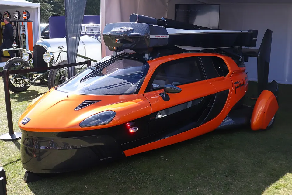 Orange and black PAL-V Liberty three-wheeled gyroplane car with its rotor folded on the roof